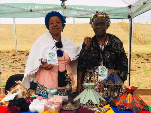 :- Rosina Kabini (left) a craftswoman who designs handmade items from animal skin, wood and raffia is with Betty Mahlangu (right) displaying her crafted unique glass creation.