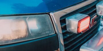 Detailed shot of a blue paramedics ambulance showing the front grill and headlight.