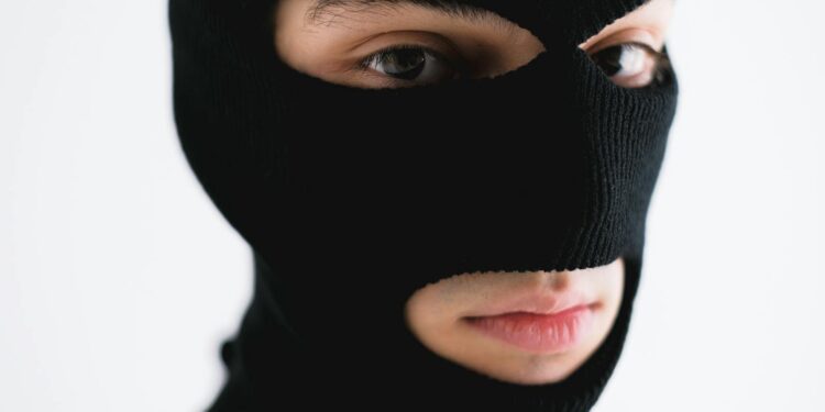 Close-up of a person wearing a black balaclava, conveying mystery or anonymity.