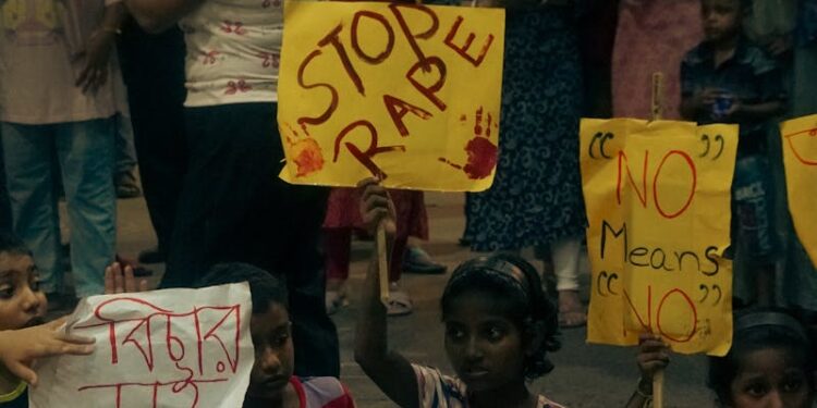 A group of people gather for a protest advocating women's safety at night.
