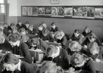 grayscale photo of people sitting on chair