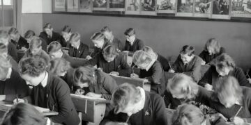 grayscale photo of people sitting on chair