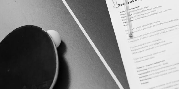Black and white photo of a table tennis racket and a document on a table, featuring copyspace.